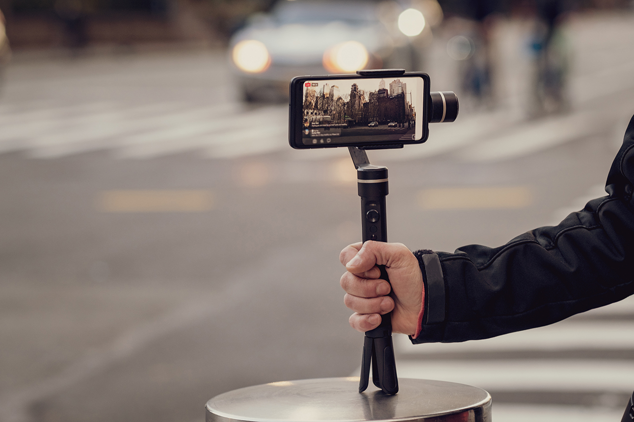 Phone with stabilizer, tripod, gimbal. Taking pictures and live video in New York city. Vlog, video blogging, street photography concept. Copyspace